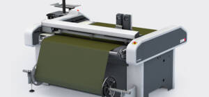 Zünd S3 M-800 digital cutting system with a roll-off unit processing olive green fabric. Zünd S3 M-800 digital cutting system with a roll-off unit processing olive green fabric.