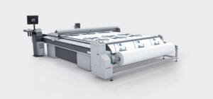Zünd digital cutting system with a center winder, processing a roll of printed material on a large flatbed. Zünd digital cutting system with a center winder, processing a roll of printed material on a large flatbed.