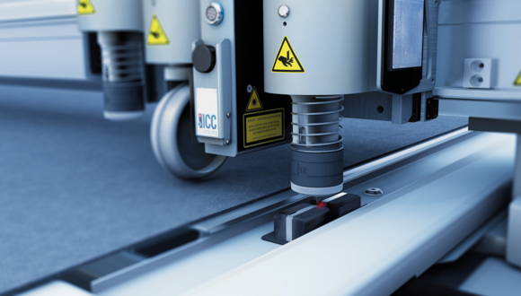 Zünd cutting system tool head with integrated camera initializing on a material surface, showing laser guidance. Zünd cutting system tool head with integrated camera initializing on a material surface, showing laser guidance.