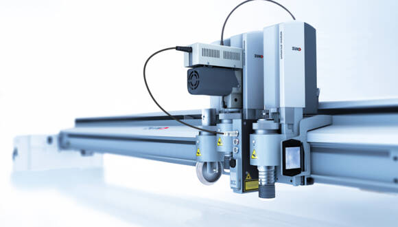 Close-up of a Zünd G3 L-3200 cutting system with a Universal Module, showcasing its precision cutting tools and components. Close-up of a Zünd G3 L-3200 cutting system with a Universal Module, showcasing its precision cutting tools and components.