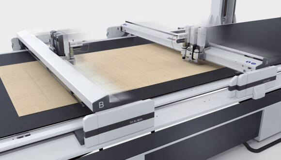 Zünd D3 XL-3200 digital cutter with multiple moving heads precisely cutting patterns on a light brown material. Zünd D3 XL-3200 digital cutter with multiple moving heads precisely cutting patterns on a light brown material.