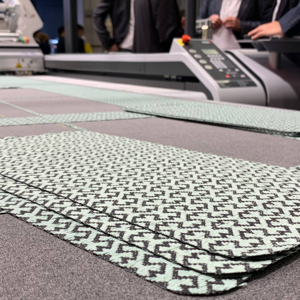 Des pièces de tissu découpées avec précision par un système Zünd sur un tapis de découpe lors de l'Interzum 2023. Des pièces de tissu découpées avec précision par un système Zünd sur un tapis de découpe lors de l'Interzum 2023.