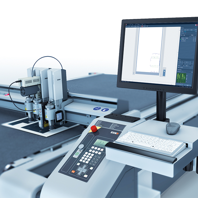 Zünd cutting system with a computer monitor displaying design software, keyboard, mouse, and dual cutting tools. Zünd cutting system with a computer monitor displaying design software, keyboard, mouse, and dual cutting tools.