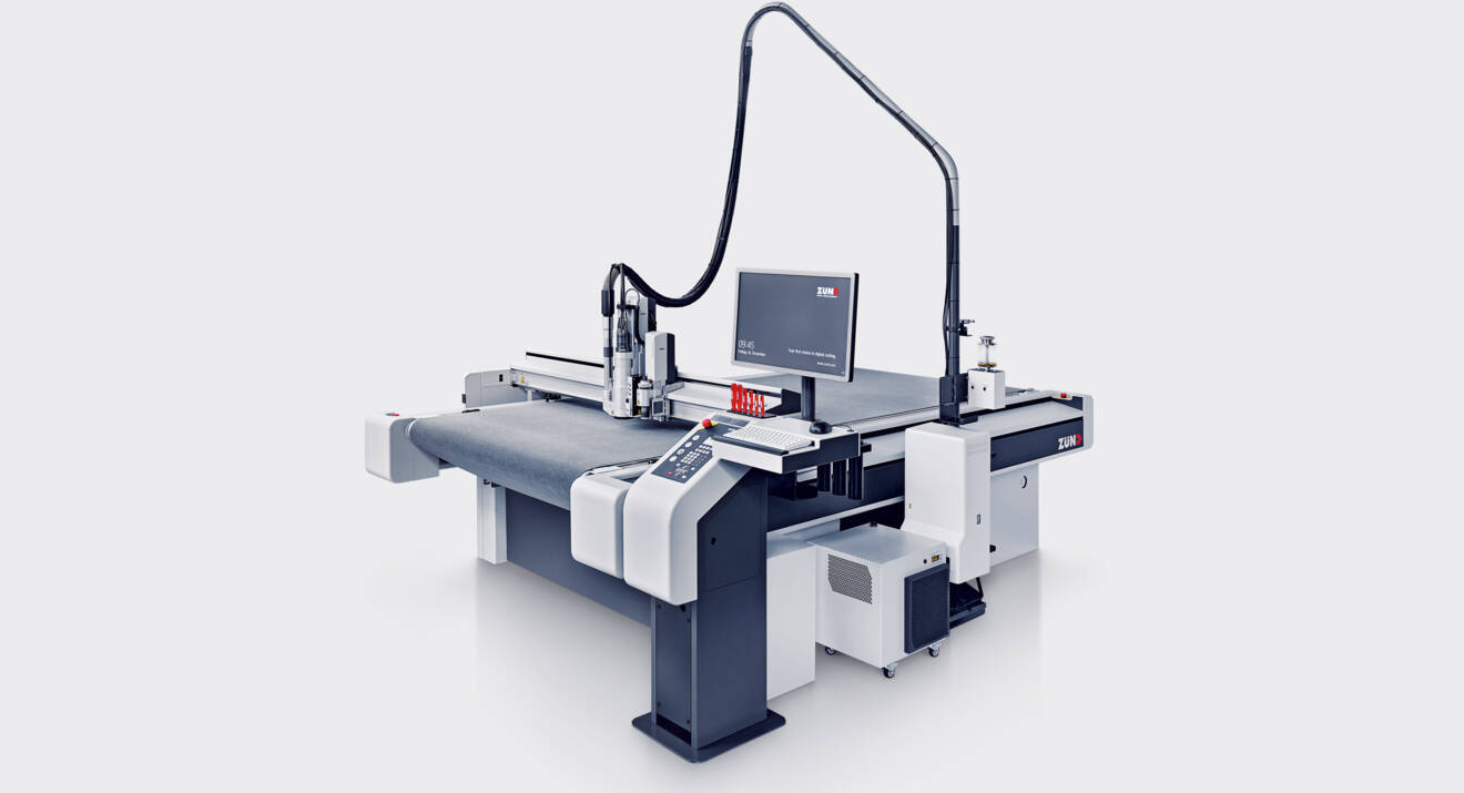 Système de fraisage Zünd RM-L avec écran, bras de câble et table de coupe, présenté sur fond gris clair. Système de fraisage Zünd RM-L avec écran, bras de câble et table de coupe, présenté sur fond gris clair.