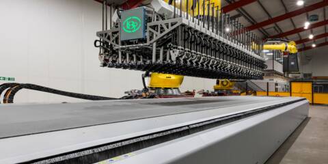 Automated cutting system with a robotic arm and a wide conveyor belt in a factory setting. Automated cutting system with a robotic arm and a wide conveyor belt in a factory setting.